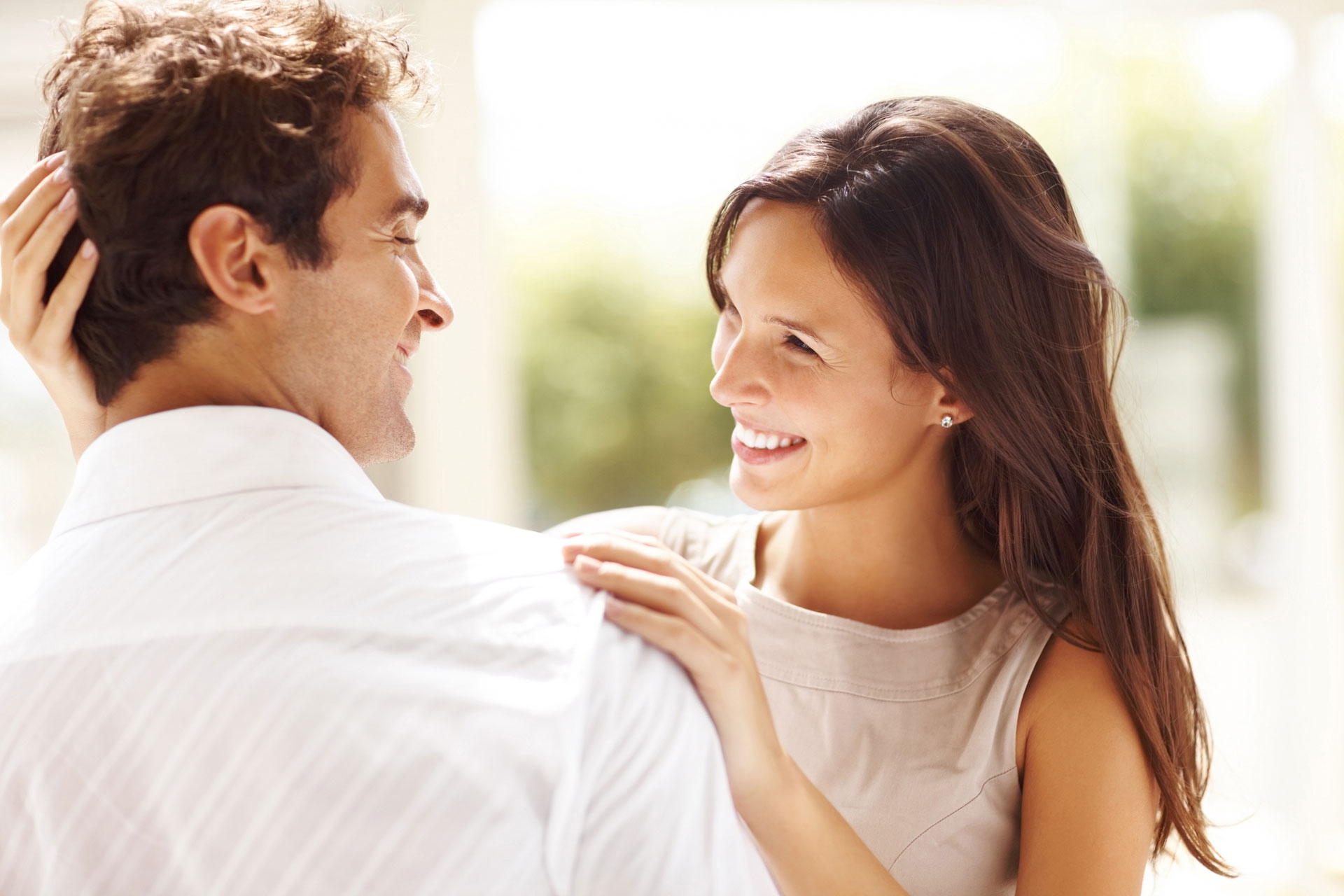 A happy couple smiling at one another after relationship counseling